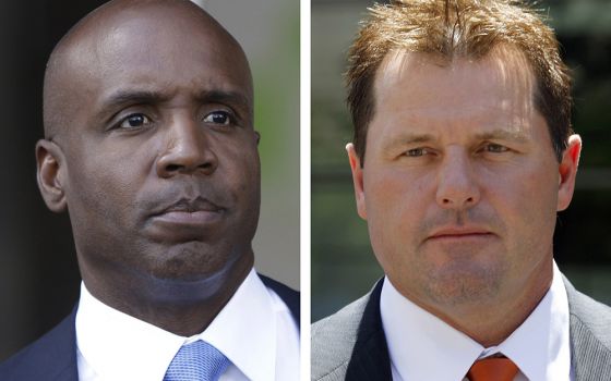 At left, in a 2011 file photo, former San Francisco Giants baseball player Barry Bonds leaves federal court in San Francisco; at right, in a 2011 file photo, former Major League baseball pitcher Roger Clemens leaves federal court in Washington. (AP)