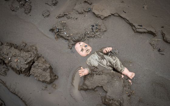 After hurricane Eta and Iota in 2020, a child's doll is stuck in the mud in a street in Chamelecón, San Pedro Sula, Honduras. Scientists say climate change is making storms like those more frequent and more severe. (Photo courtesy of Sean Hawkey, World Co