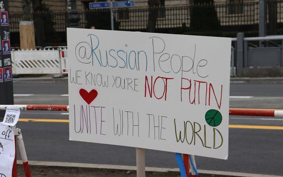 A sign decrying Vladimir Putin and the war in Ukraine is seen outside the Russian Embassy in Berlin March 4. (NCR photo/Teresa Malcolm)