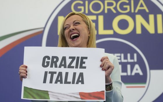 Giorgia Meloni shows a placard reading in Italian "Thank you Italy" at the Brothers of Italy party's electoral headquarters in Rome Sept. 26. (AP/Gregorio Borgia)