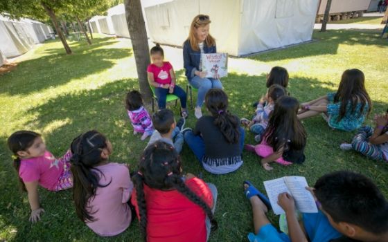Jean Stamatis, a volunteer from Sts. Faith, Hope and Charity Parish in Winnetka, Illinois, reads to children as part of the Literacy Wagon program for children of migrant families in the Diocese of Yakima, Washington. (Catholic Extension/Rich Kalonick)