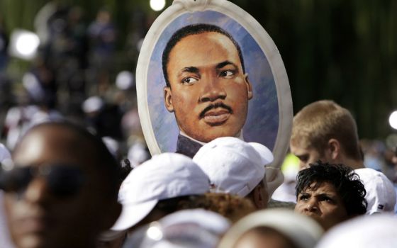 A woman holds a portrait of the Rev. Martin Luther King Jr. during the 2011 dedication of the King memorial at the National Mall in Washington. (CNS/Reuters/Yuri Gripas) 
