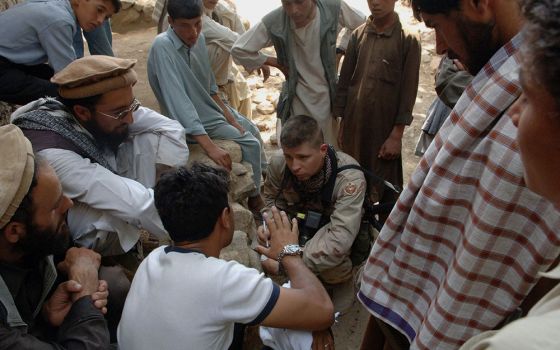Sgt. Matthew MacRoberts, center, of Task Force Eagle, interviews the local mullah in the village of Qual-A-Atakhom, Afghanistan. Task Force Eagle conducted medical civilian assistance procedures in the village on Aug. 16, 2005. (U.S. Army/SPC Joshua Balog