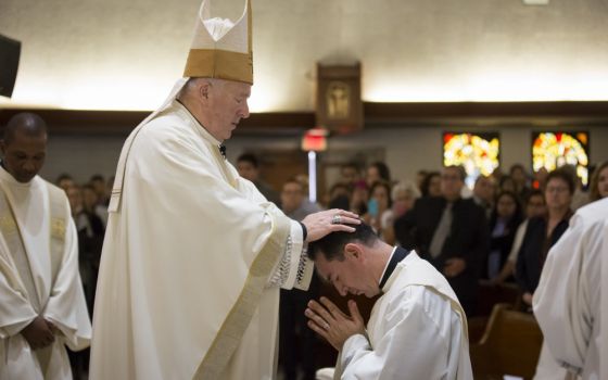 San Diego Bishop Robert McElroy lays hands on Jesuit ordinand Alejandro Báez during the June 9 ordination Mass at Our Lady of Mount Carmel Parish in San Ysidro, California, near the U.S.-Mexico border. (Jon Rou)
