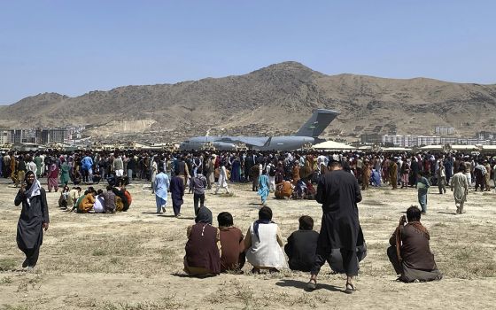 Hundreds of people gather near a U.S. Air Force C-17 transport plane at the perimeter of the international airport Aug. 16, 2021, in Kabul, Afghanistan. (AP photo/Shekib Rahmani, File)