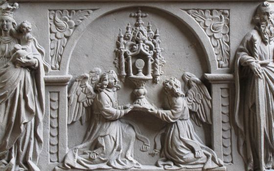 Eucharistic adoration is depicted in relief on a 1624 baptismal font at the Jesuit Church in Molsheim, France. (Wikimedia Commons/©Ralph Hammann)