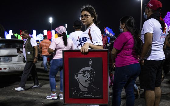 A youth carries a portrait of Nicaraguan President Daniel Ortega during commemorations late Sunday, July 18, for the anniversary of the triumph of the 1979 Sandinista Revolution that toppled dictator Anastasio Somoza in Managua, Nicaragua. (AP Photo)