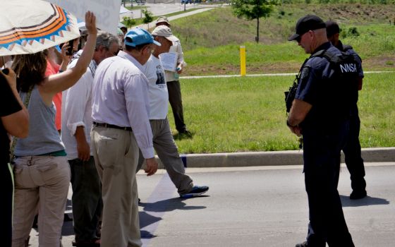 Tom Fox steps over a purple line painted on a road leading to the Kansas City National Security Campus on Memorial Day, May 28, in Kansas City, Missouri. (Jeff Davis)