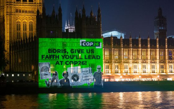 An image projected onto Parliament in London Oct. 25 urges British Prime Minister Boris Johnson to show leadership at the U.N. climate conference, COP26, which opens Oct. 31 in Glasgow, Scotland.