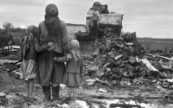 A woman and two girls look at their destroyed house during World War II in Russia in the Soviet Union, Sept. 1, 1943. (Wikimedia Commons/RIA Novosti archive, image #982/S. Alperin/CC-BY-SA 3.0)