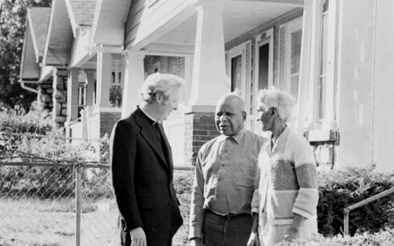 In 1977, Fr. Norm Rotert talks with Robert and Delia Harris, who were living in a home they got through the Blue Hills Homes Corporation, founded by Rotert in Kansas City, Missouri. (NCR photo/Bob Hart)