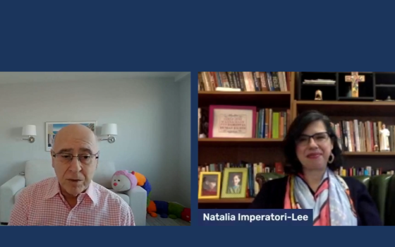Michael Leach (left, in pink shirt) speaks with Natalia Imperatori-Lee.