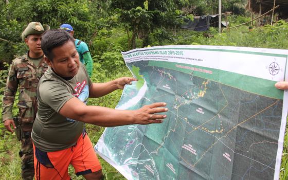 A community leader in Peru's Ucayali region indicates on a map the area where outsiders cleared land to plant coca, the main ingredient in cocaine. (Barbara Fraser)