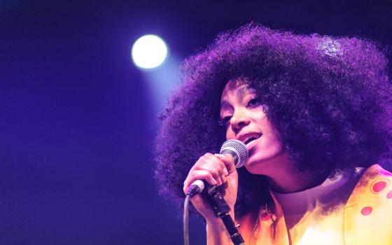 Solange holding a microphone and singing