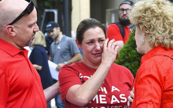 In this June 11, 2019 file photo, Jules Woodson, center is comforted by her boyfriend Ben Smith, left, and Christa Brown during a demonstration outside the Southern Baptist Convention's annual meeting in Birmingham, Alabama. (AP photo/Julie Bennett, file)