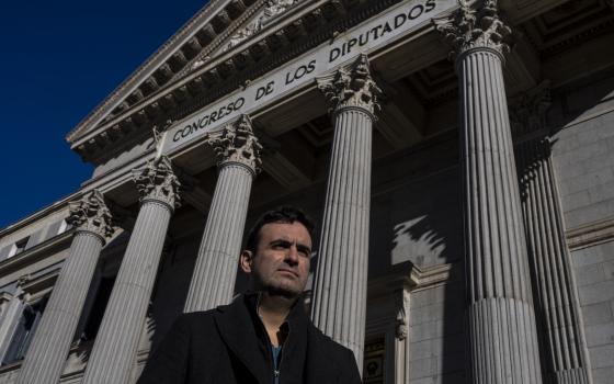 Miguel Hurtado, who has campaigned against impunity since disclosing his own account of being abused at a monastery in northeastern Spain, poses for a picture in front of a Spanish parliament in Madrid, Spain, Tuesday, Feb. 1, 2022. (AP Photo/Manu Fernand