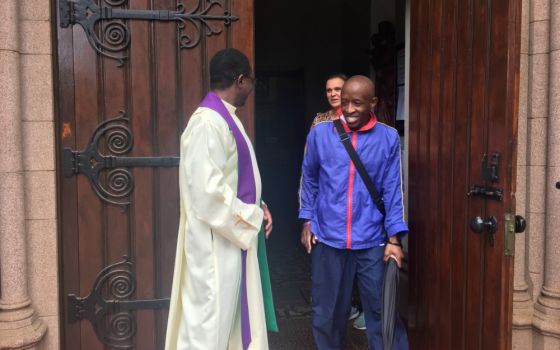 A parishioner talks with Fr. Norbert Munekani after Mass at Holy Trinity Catholic Church in Johannesburg, before the South African government imposed a lockdown to combat the coronavirus outbreak. (Patrick Egwu)