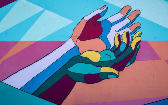 Photo of a mural of multicolored hands (Unsplash/Tim Mossholder)