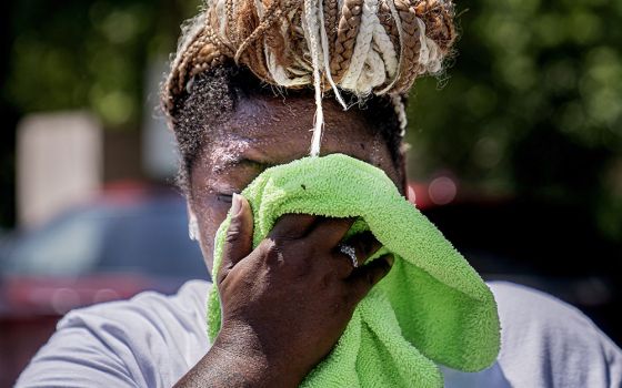 Nicole Brown wipes sweat from her face while setting up her beverage stand near the National Mall July 22, during a heat wave in Washington, D.C. (AP/Nathan Howard)