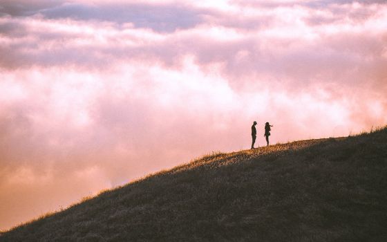 Couple on a hillside (Unsplash/Casey Horner)
