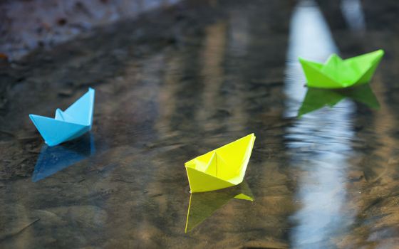 Paper boats in shallow water (Dreamstime/Gyso4ka)
