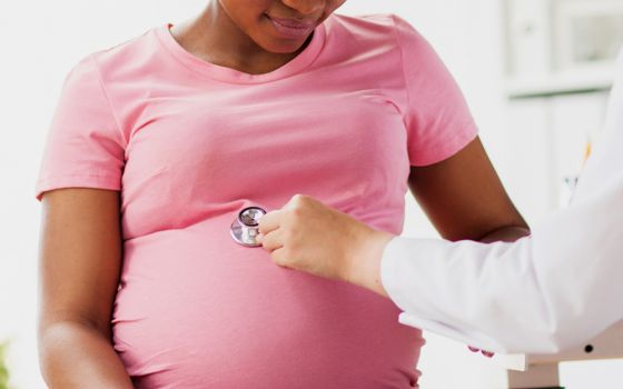 Pregnant Black woman seeing a doctor (Dreamstime/Syda Productions)
