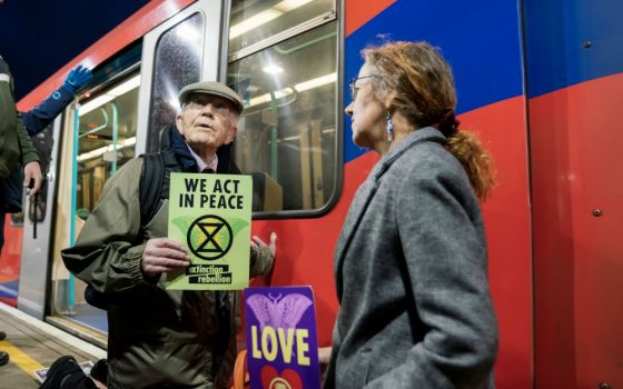 Phil Kingston, 83, a former parole officer, protests climate change after super-gluing himself to the side of a train on the platform at London's Shadwell Station Oct. 17. (Courtesy of Extinction Rebellion/ Vladimir Morozov)