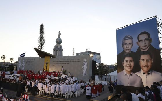 A poster depicting the Rev. Rutilio Grande, Franciscan priest Cosme Spessotto, Nelson Lemus and Manuel Solorzano, all victims of right-wing death squads during El Salvador's civil war, is shown during a beatification ceremony Jan. 22 in San Salvador. (AP)