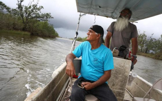 Donald Dardar, left, and Russell Dardar look toward the eroding shoreline of Bayou Pointe-au-Chien in southern Louisiana on Wednesday, Sept. 29, 2021. (AP/Jessie Wardarski)