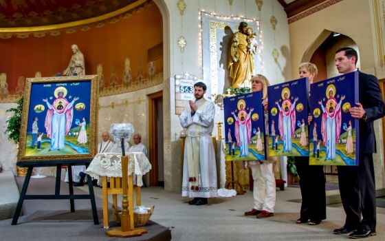 Members of the Catholic Community of Flint in Michigan present an icon of Mother, Mary of Flint at St. Mary Church, along with replicas to be placed in the three other churches of the community on Mother's Day, May 13. (Gary Pearce)