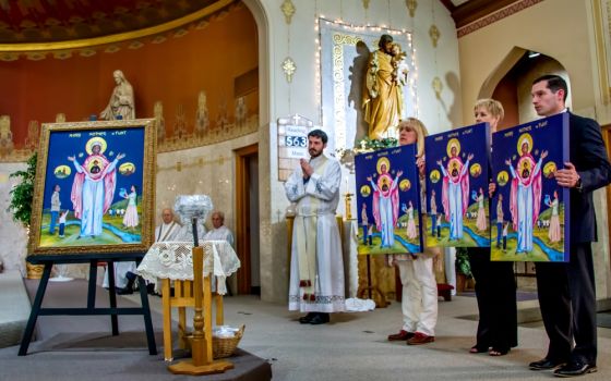 Members of the Catholic Community of Flint in Michigan present an icon of Mother, Mary of Flint at St. Mary Church, along with replicas to be placed in the three other churches of the community on Mother's Day, May 13. (Gary Pearce)