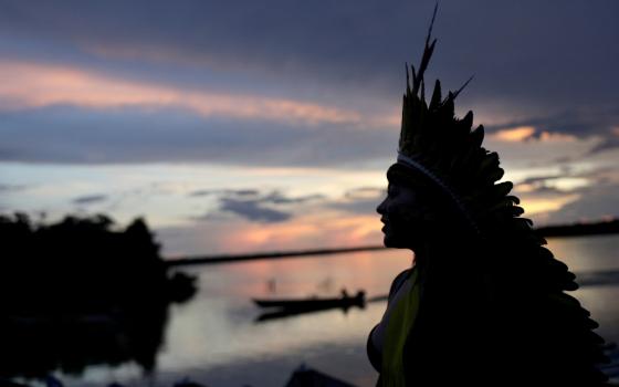 A leader of the Celia Xakriaba peoples walks along the banks of the Xingu River in Brazil's Xingu Indigenous Park Jan. 15. (CNS/Reuters/Ricardo Moraes)