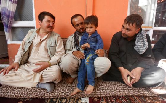 Ali Ahmad, 4, sits with his father and relatives at their house after he survived a suicide attack at a mosque in Kabul, Afghanistan, Aug. 27. (Newscom/Reuters/Omar Sobhani)