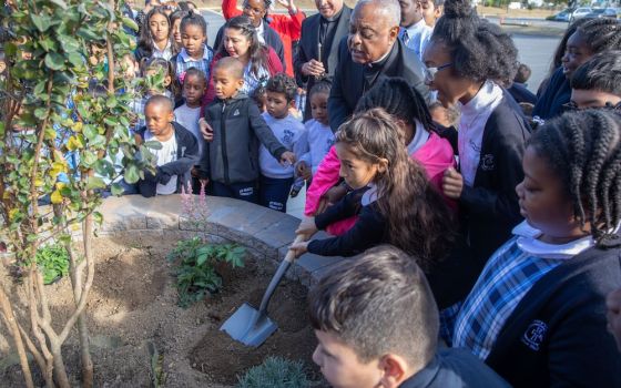 In this 2019 photo, then-Archbishop Wilton D. Gregory of Washington joins students at St. Mary's School in Landover Hills, Maryland, in planting a tree in celebration of the school's 65th anniversary. (CNS photo/Andrew Biraj, Catholic Standard)