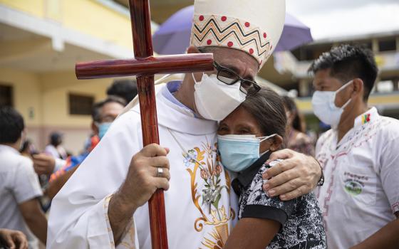 Newly ordained Bishop Miguel Angel Cadenas of Iquitos, Peru, embraces Ligia Saboya, who coordinates the Catholic community in her small village of Reforma on the Urituyacu River in Peru's northeastern Loreto region. (Ginebra Peña)