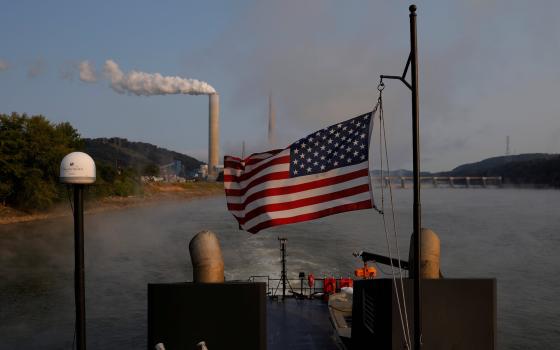 A towboat passes a coal-fired power plant along the Ohio River in Stratton, Ohio, in 2017. (CNS photo/Brian Snyder, Reuters)