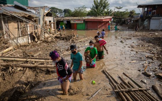 Residents walk through mud in Manila, Philippines, Nov. 14, 2020, after flooding caused by Typhoon Vamco. (CNS/Reuters/Eloisa Lopez)