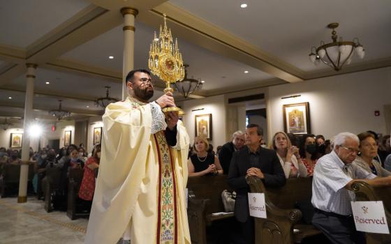 Fr. Jason Espinal, administrator of Sts. Peter & Paul-Epiphany Parish in the Brooklyn borough of New York City, processes with a reliquary containing the relics of Sts. Peter and Paul during the dedication of the church on its patronal feast June 29. (CNS