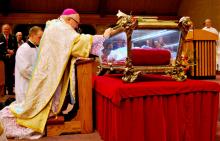 Bishop Robert Morlino of Madison, Wisconsin, venerates relics of St. Maria Goretti at St. Maria Goretti Church in Madison in 2015. (CNS/Catholic Herald/Kevin Wondrash)