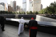 Pope Francis prays at the south fountain at the ground zero 9/11 Memorial Sept. 25, 2015, in New York. The pope is accompanied by Cardinal Timothy Dolan of New York. (CNS/Paul Haring)