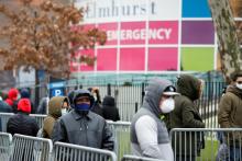 People wearing protective gear wait in line to be tested for the coronavirus (COVID-19) outside Elmhurst Hospital Center in the Queens borough of New York City March 25. (CNS/Reuters/Stefan Jeremiah)