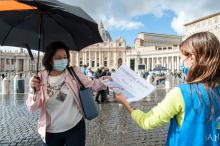 Free copies of the Vatican newspaper L'Osservatore Romano with the front page about Pope Francis' encyclical "Fratelli Tutti" are distributed by volunteers at the end of the Angelus in St. Peter's Square at the Vatican Oct. 4. (CNS/IPA/Reuters/Sipa USA)