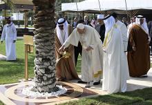Pope Francis waters a palm tree before addressing the Bahrain Forum for Dialogue: East and West for Human Coexistence Nov. 4 in Awali, Bahrain. (CNS/Vatican Media)