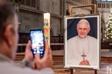 Person takes photo of photo of Pope Benedict