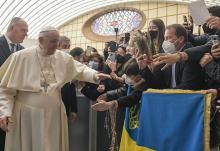Pope Francis walks near a flag with the national colors of Ukraine during his general audience in the Paul VI hall at the Vatican March 16. (CNS/Vatican Media)
