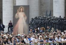 An image of Jesus of Divine Mercy and the "Angels Unawares" sculpture are seen in St. Peter's Square as people wait for Pope Francis to lead the "Regina Coeli" April 24, 2022, at the Vatican. (CNS/Paul Haring)