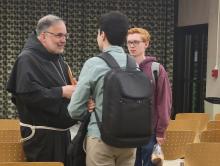 Bishop John Stowe of Lexington, Kentucky talks with students from Loyola University Chicago after the bishop's talk on "Synodality and the Common Good" April 11. (NCR photo/Heidi Schlumpf)