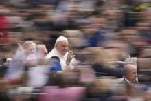 Pope Francis rides through a blurred out crowd of people