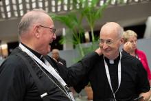 New York Cardinal Timothy Dolan and Jesuit Fr. James Martin, editor at large of America magazine, share a laugh during a break at the assembly of the Synod of Bishops in the Vatican's Paul VI Audience Hall Oct. 11. (CNS/Vatican Media)