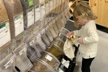 Kara Daddario Bown's 3-year-old daughter fills a reusable cotton bag with food from the bulk section of a grocery store. At home, Bown and her daughter transfer the bulk food into glass jars that they store in their pantry. (Courtesy of Kara Daddario Bown)